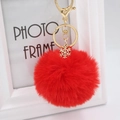 Detail of red plush pom-pom keychain with golden snowflake charm and lobster clasp - Red