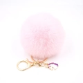 Detail view of pink faux fur pompom keychain with golden clasp and unicorn charm - Small Unicorn Keychain / Light Pink