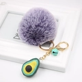 Detail of purple faux fur pompom keychain with golden clip and avocado charm - Avocado Keychain / Two-tone Purple