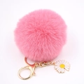Détail d'un porte-clés en peluche rose avec fermoir doré et petit pendentif en forme de marguerite - Rose foncé