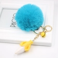 Detail of creative blue faux fur pom-pom keychain with banana charm and golden metal hook - Lake Blue
