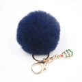 Détail d'un porte-clés pompon bleu marine en fausse fourrure avec breloque sapin de Noël dorée - Bleu Marine