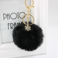Detail of black fluffy faux fur pompom keychain with golden snowflake alloy charm - Black