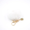 Détail d'un porte-clés pompon blanc avec mousqueton doré et breloque flocon de neige - Blanc