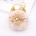 Detailed view of pink cat plush pompom keychain with golden ears and metallic whiskers - Mixed Khaki