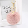 Close-up of pink fluffy pompom keychain with golden snowflake charm and lobster clasp - Dusty Pink