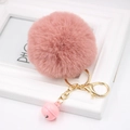Detail of pink faux rabbit fur keychain with gold lobster clasp and small bell - Dusty Pink