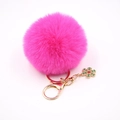 Vue détaillée d'un porte-clés pompon violet rose avec pendentif flocon de neige doré - Rose rouge