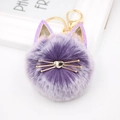 Detail of purple plush cat keychain with golden whiskers and shimmering ears on white background - Two-tone Purple