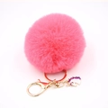 Close-up of pink fluffy pompom keychain with golden clasp and cute unicorn charm - Small Unicorn Keychain / Watermelon red