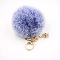Détail d'un porte-clés pompon en fausse fourrure violette avec breloque flocon dorée - Bleu Bicolore