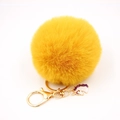 Detailed view of ginger yellow fluffy fur pompom with golden unicorn enamel keychain charm - Small Unicorn Keychain / Orange