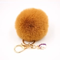 Detail of tan faux fur pom pom keychain with gold ring and purple unicorn charm - Small Unicorn Keychain / Coffee