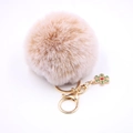 Détail d'un porte-clés en fausse fourrure avec flocon de neige doré et fermoir homard - Bicolore Kaki