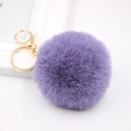 Close-up of purple faux rabbit fur ball with golden metal lobster clasp and keychain - Violet