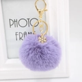 Plush purple pompom keychain with golden snowflake charm and secure metal clasp - Violet