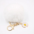 Détail d'un porte-clés marguerite blanche à pompon avec fermoir doré et breloque fleur - Blanc