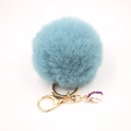 Close-up of a light blue faux fur pompom keychain with a gold unicorn charm and lobster clasp - Small Unicorn Keychain / Teal