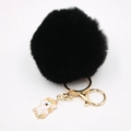 Vue détaillée du porte-clés pompon en fausse fourrure noire avec breloque licorne dorée - Porte-clés Licorne / Noir