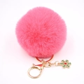 Détail d'un porte-clés pompon rose avec fermoir doré et breloque flocon de neige émaillée - Rouge pastèque