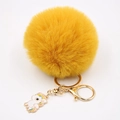 Détail du porte-clés pompon jaune avec pendentif licorne dorée et fermoir mousqueton - Porte-clés Licorne / Orange