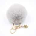 Détail du porte-clés pompon gris avec fermoir doré et pendentif flocon de neige - Gris clair