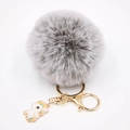 Détail du porte-clés pompon en fourrure grise avec breloque licorne et métal doré - Porte-clés Licorne / Bicolore Gris
