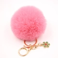 Détail d'un porte-clé pompon rose avec fermoir doré et charm flocon de neige - Rose foncé