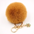 Détail du porte-clés pompon en fausse fourrure marron avec charm flocon de neige - Café