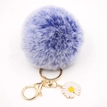 Détail d'un pompon en fausse fourrure violette avec breloque marguerite dorée et fermoir - Double Bleu
