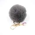 Detailed close-up of dark grey faux fur pom pom keychain with gold ring and purple unicorn charm - Small Unicorn Keychain / Dark Gray