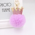 Détail d'un porte-clés en fausse fourrure violette avec couronne rose et perles blanches - Violet Taro