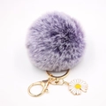 Détail du porte-clés pompon en fausse fourrure violette avec fermoir doré et pendentif marguerite - Bicolore Violet