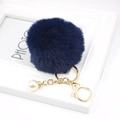 Detailed view of deep blue faux fur keychain with golden hardware and pearl charm - Navy Blue