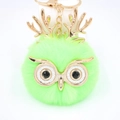 Détail du porte-clés hibou en fausse fourrure verte avec bois dorés et yeux noirs brillants - Porte-clés Doré / Vert Fluorescent