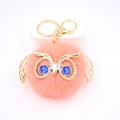 Détail de porte-clés hibou en fausse fourrure avec cadre en or et yeux en pierres bleues - Porte-clés Doré / Rouge Orangé