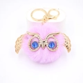 Détail d'un porte-clés hibou en peluche rose avec ailes dorées et yeux perlés - Porte-clés Doré / Violet Taro