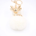 Détail du porte-clés tête de renne dorée avec un grand pompon blanc en fausse fourrure douce - Blanc Cassé