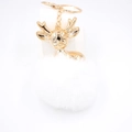 Détail d'un porte-clés tête de cerf dorée avec pompon en fourrure blanche et chaîne - Blanc