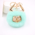 Close-up of mint green faux fur pompom keychain with golden bull horns and ring - Gold Keychain / Mint Green