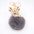 Détail d'un porte-clés cerf avec bois dorés et pompon en fausse fourrure gris foncé - Gris foncé