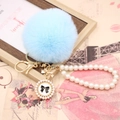 Close-up of light blue faux rabbit fur pompom keychain with pearl strap and bow charm - Pearl Bowknot / Light Blue