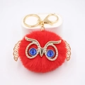Porte-clés chouette en fourrure rouge avec ailes dorées sur socle blanc épuré - Porte-clés Doré / Rouge