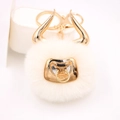Close-up of white plush bull keychain with golden horns and metallic nose ring detail - Gold Keychain / Off-white