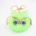 Détail du porte-clés hibou pompon vert fluo avec garnitures dorées et yeux bleus - Porte-clés Doré / Vert Fluorescent