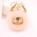 Detail view of pink plush bull keychain with golden horns and metallic nose ring detail - Gold Keychain / Pink