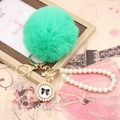 Detail of mint green faux rabbit fur pom pom with pearl chain and golden bow charm - Pearl Bowknot / Bright Green