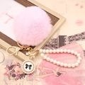 Detail of pink faux rabbit fur pom pom keychain with pearl chain and bow charm - Pearl Bowknot / Light Pink