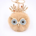 Détail d'un porte-clés chouette en peluche avec bois dorés et yeux à paillettes bleues - Porte-clés Doré / Khaki