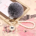 Detail of dark grey faux fur pompom keychain with pearl chain and bow charm - Pearl Bowknot / Frost Black